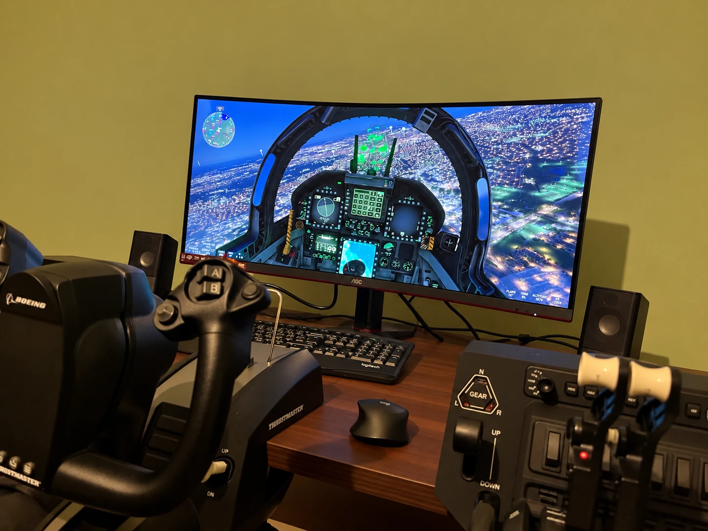 A home flight simulator setup with a Thrustmaster Boeing yoke, throttle quadrant and switch panels, facing a curved monitor showing a fast-jet cockpit.